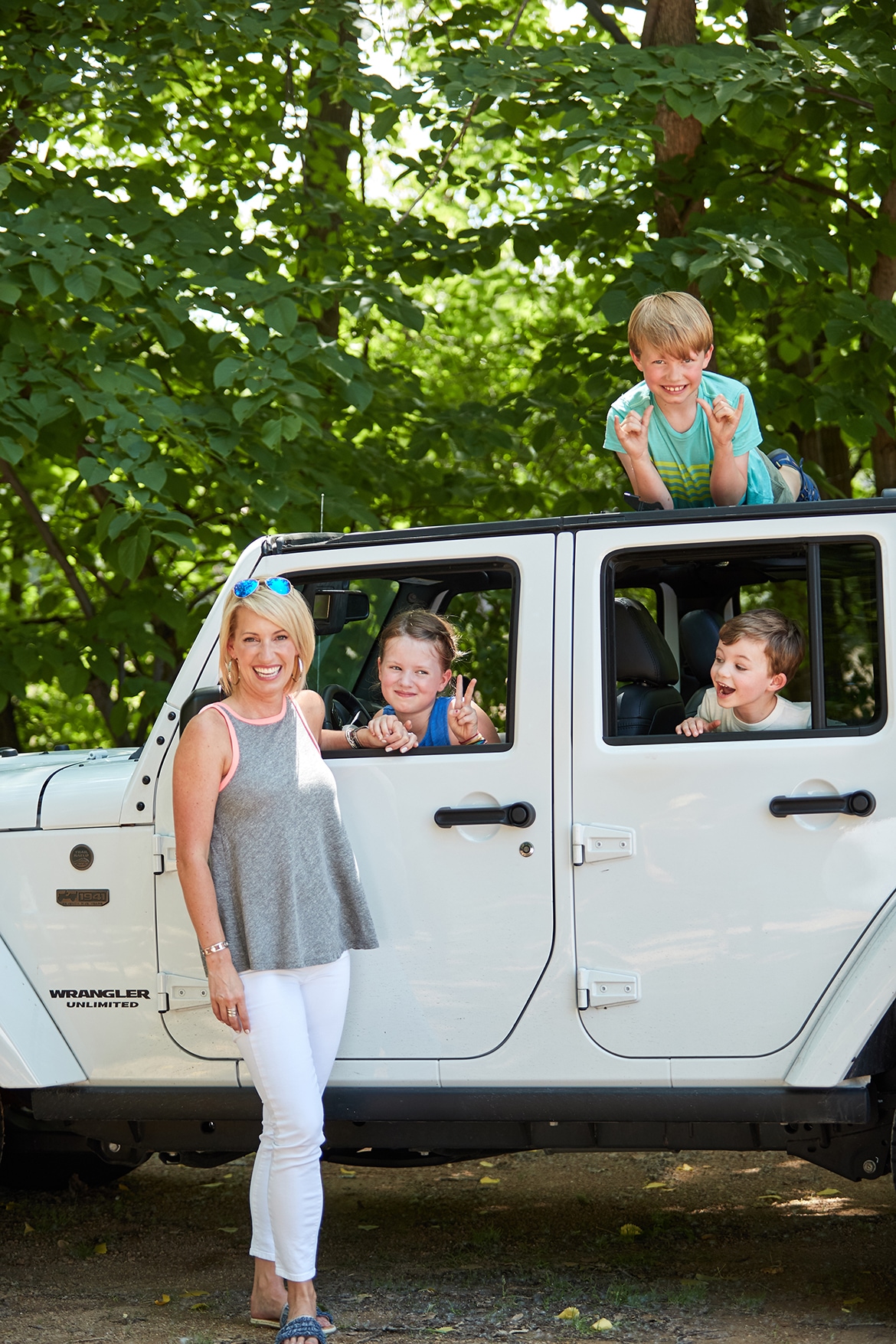 family riding in a white jeep wrangler