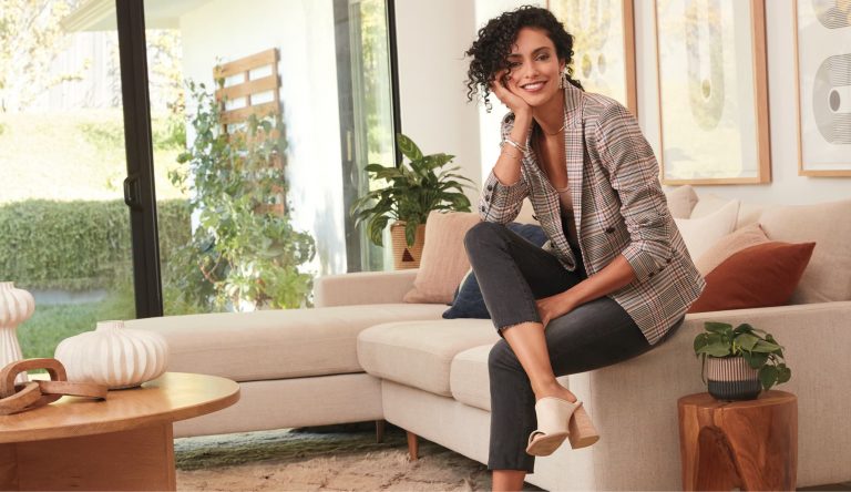 woman sitting on couch smiling.